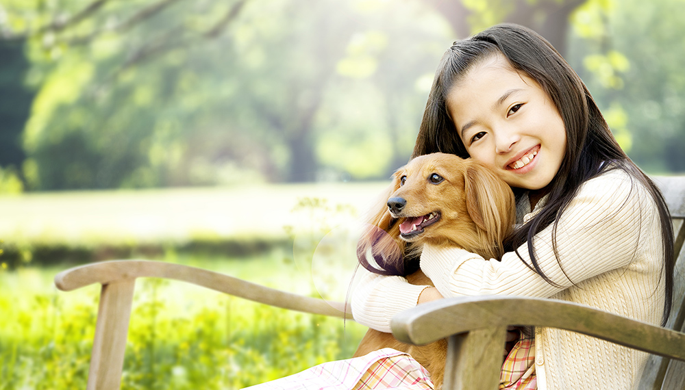 犬を抱っこしている少女